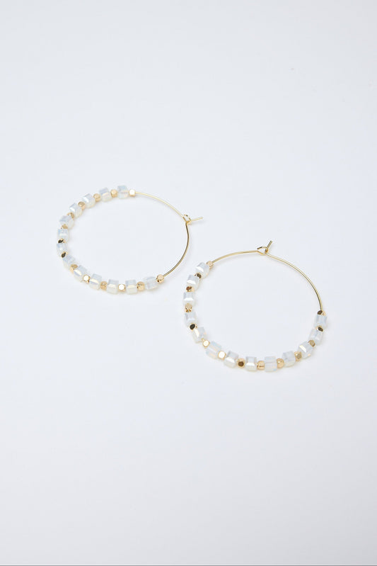 Pair of hoop earrings with pearl-like beads on a white background
