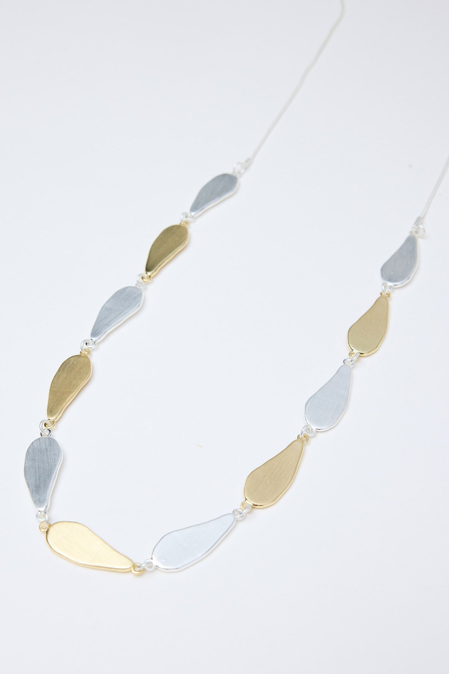 Necklace with gold and silver pendant on a white background