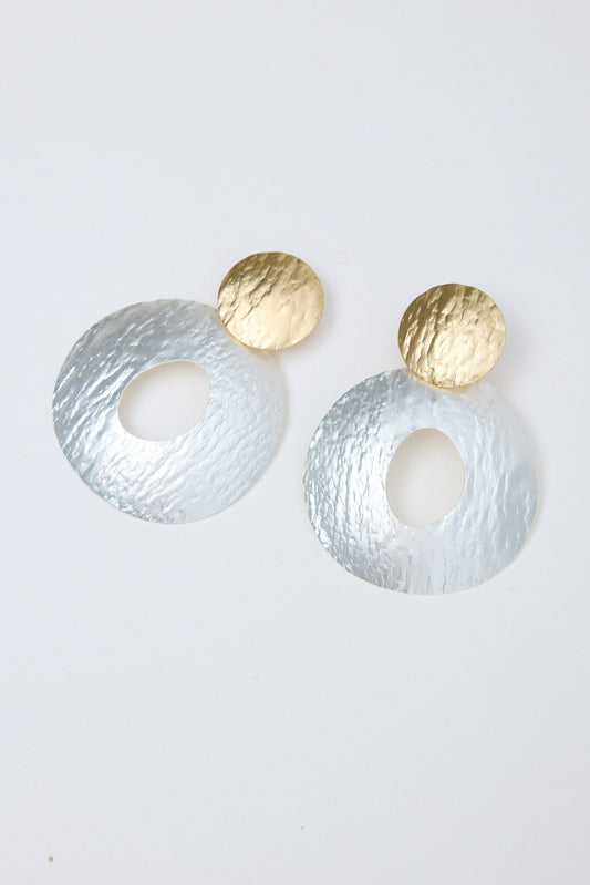 Pair of earrings with gold and silver finishes on a light gray background