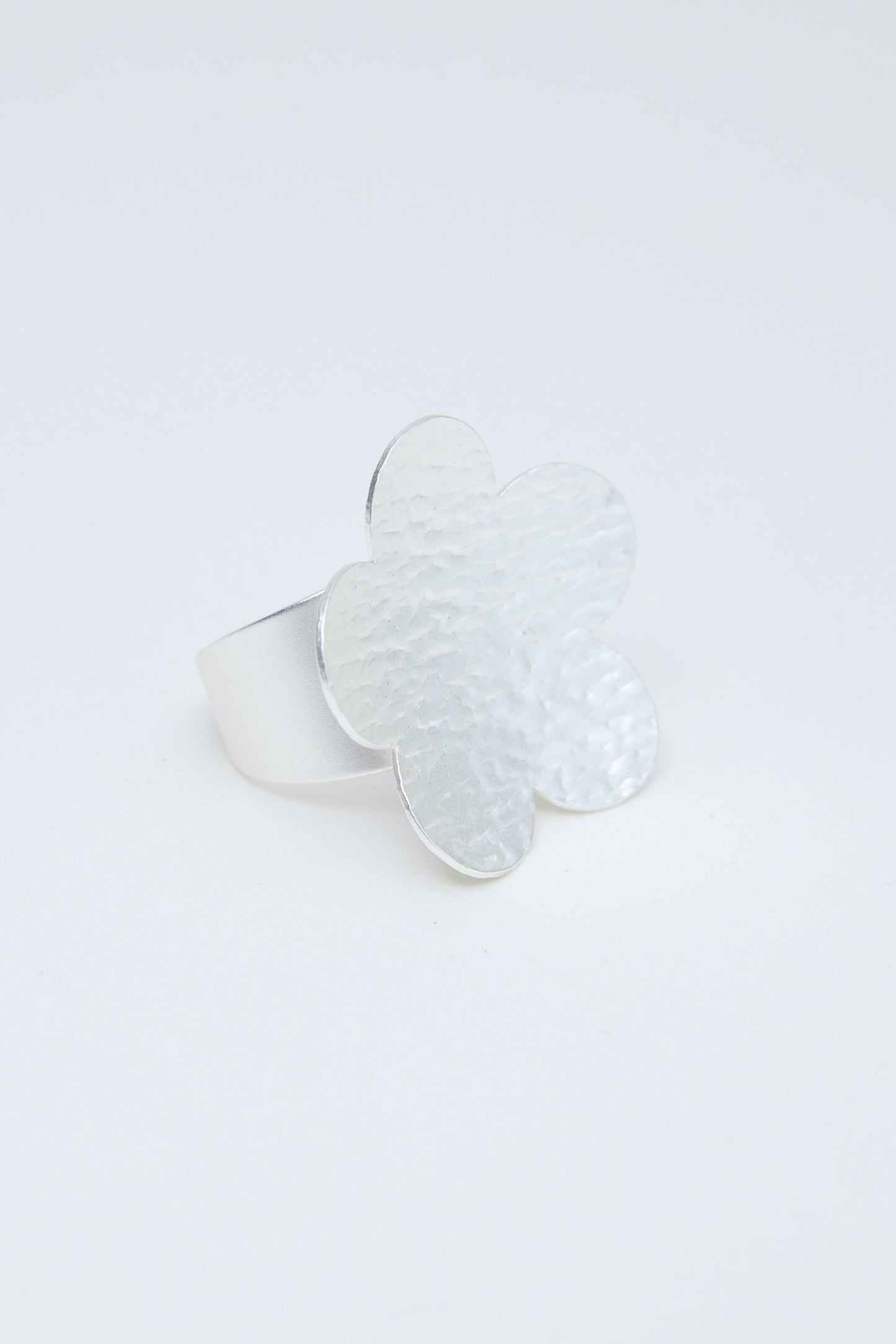 Silver flower-shaped ring on a white background