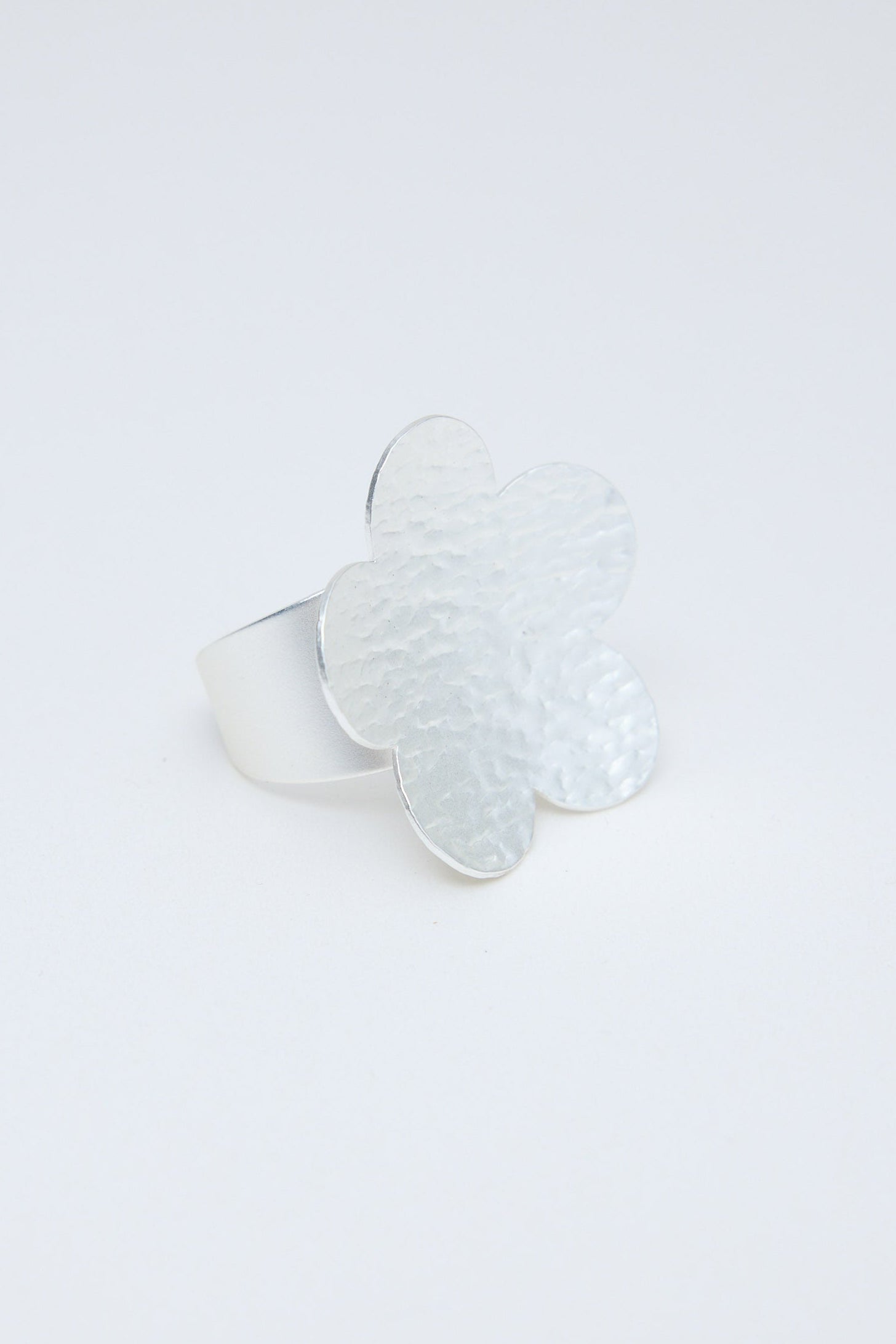 Silver flower-shaped ring on a white background