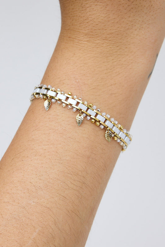 Bracelet on a wrist with a plain background