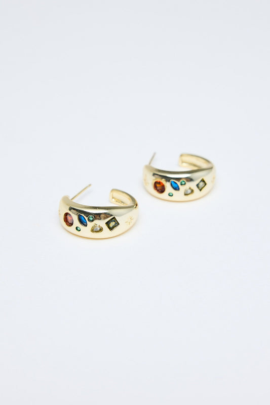 Gold hoop earrings with colorful stones on a light gray background