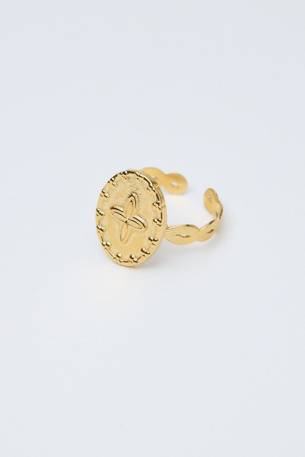 Gold ring with a unique design on a light gray background