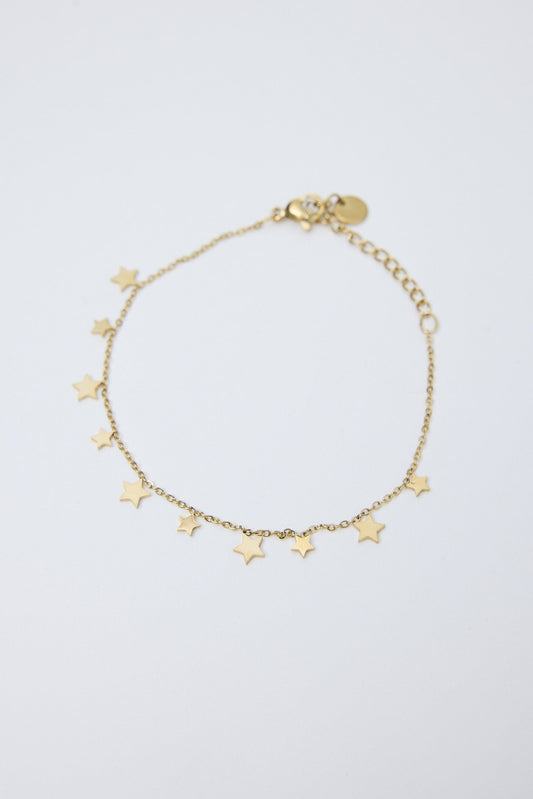 Gold bracelet with star charms on a light gray background