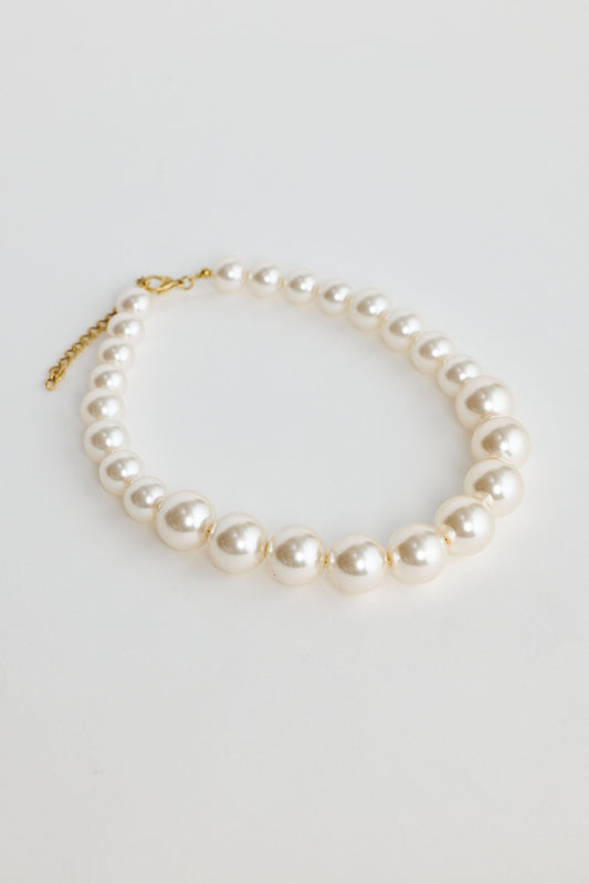 Pearl necklace on a light gray background