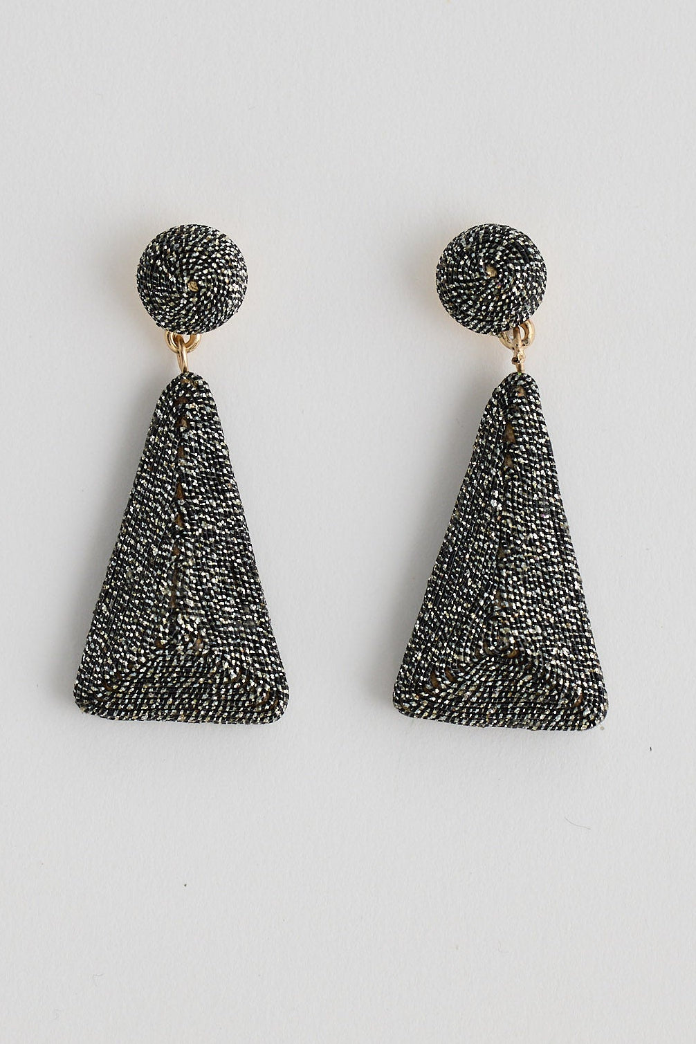 Pair of black tassel earrings on a light gray background