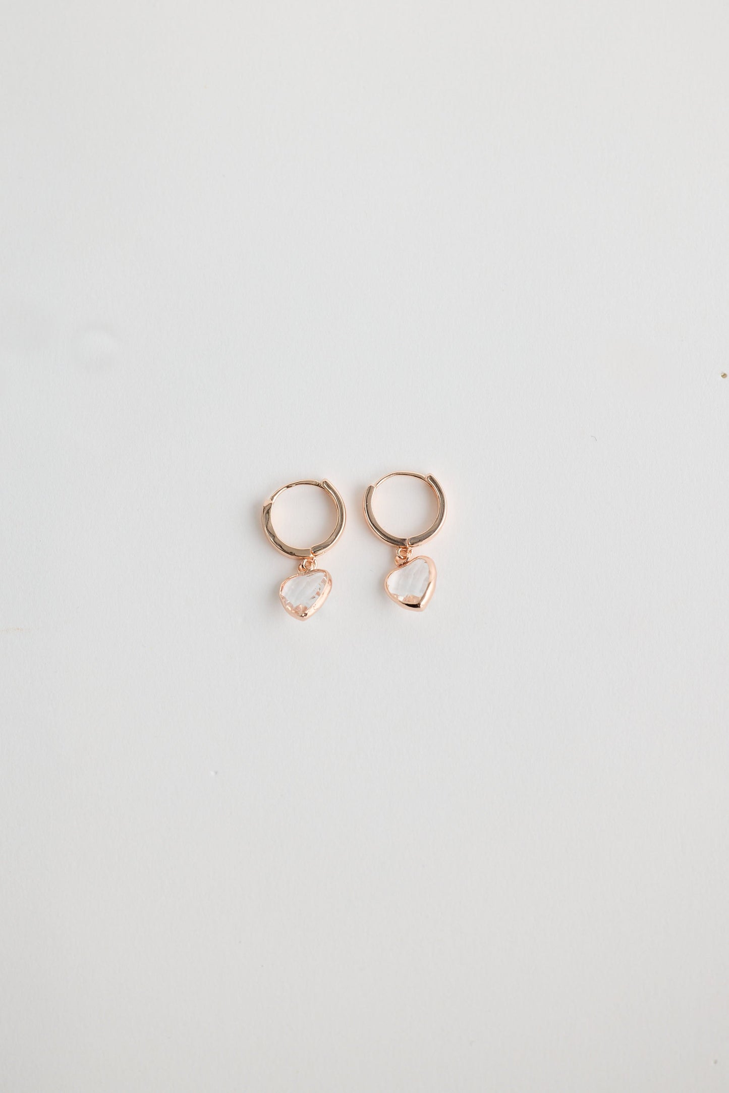Close-up of clear adore earrings earrings on white background.