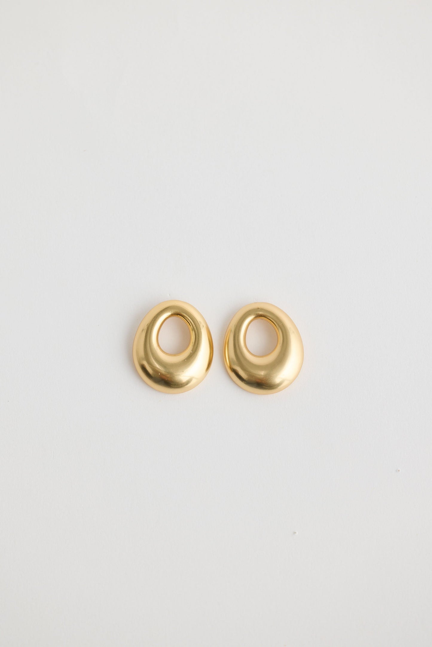 Close-up of gold jordan earrings earrings on white background.