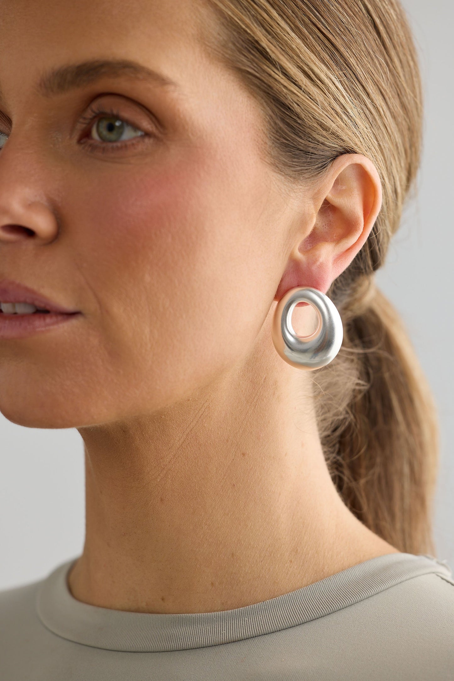 Close-up of silver jordan earrings earrings on white background.