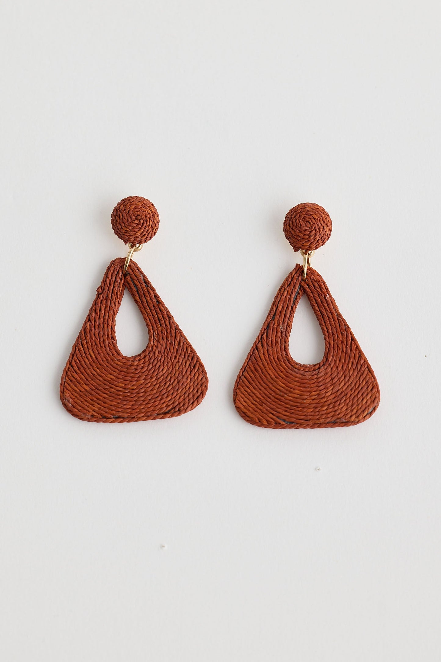 Pair of brown woven earrings on a light gray background