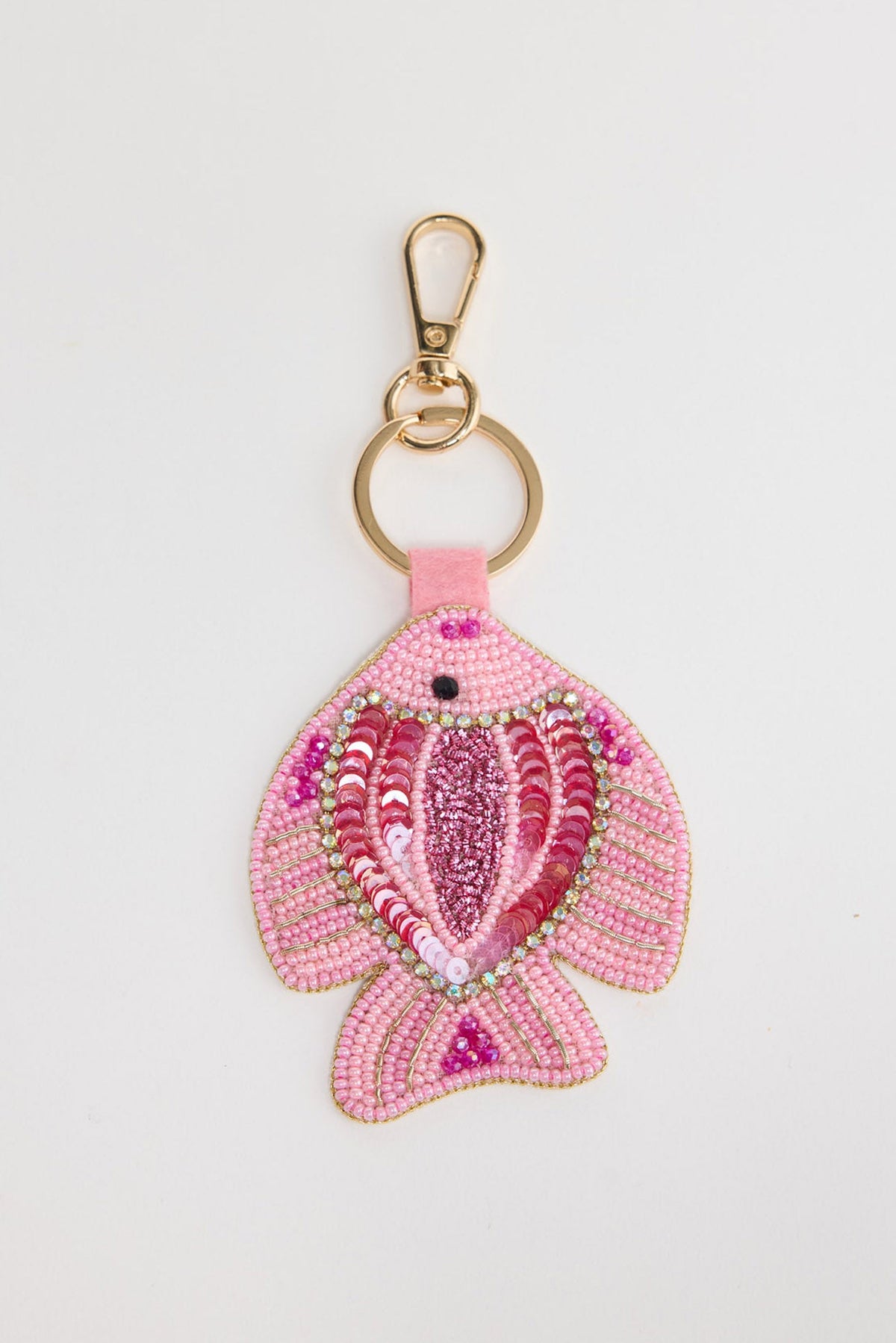 Beaded fish keyring in soft pink seed beads with hot pink and fuchsia sequin scales, crystal border detail and a black bead eye, attached to a gold-tone clasp and split ring via a pink leather tab, shown on a white background