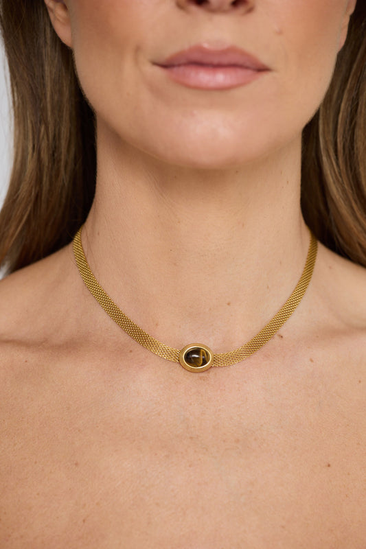Dorris Necklace in amber with a central oval stone detail, front display view on neutral background