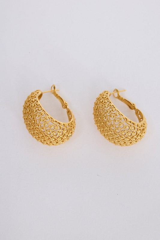 Model wearing Meadow Earrings in gold with woven texture detailing, ear detail view on neutral background
