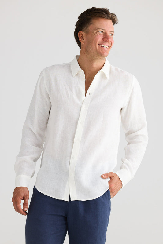 Man wearing a white shirt and blue pants on a plain background