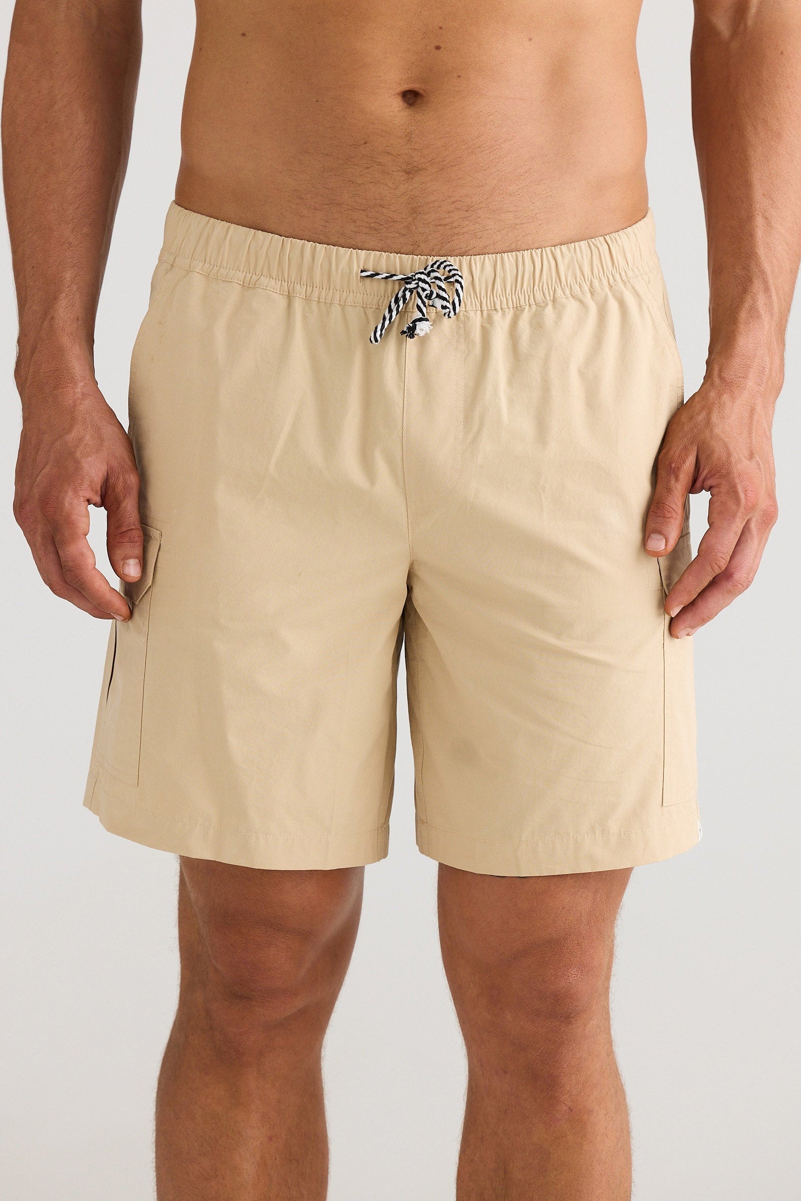 Beige shorts worn by a person on a white background