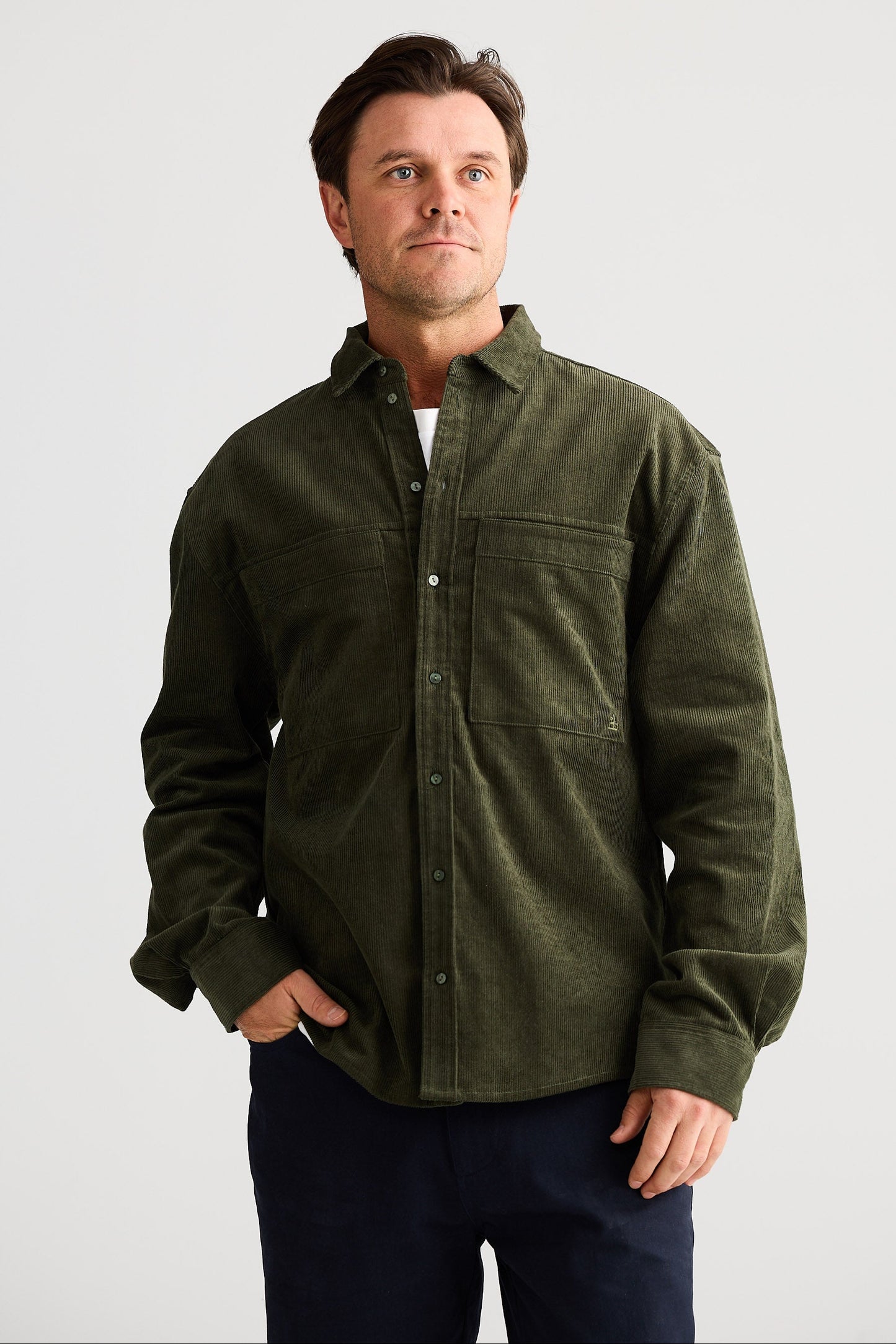 Man wearing a green shirt with a plain background