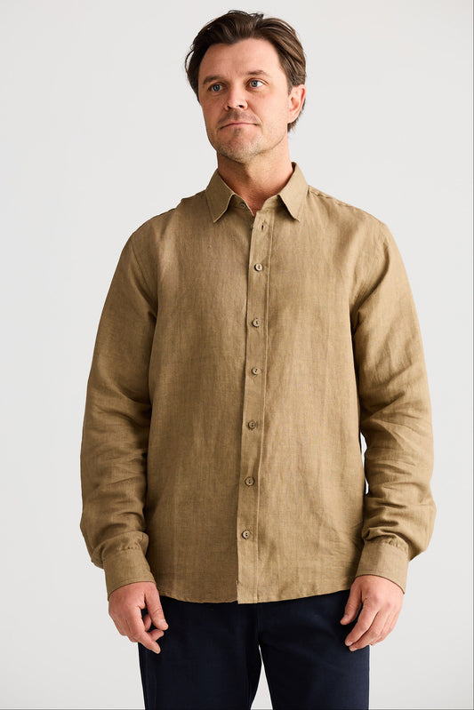 Man wearing a beige button-up shirt against a plain background