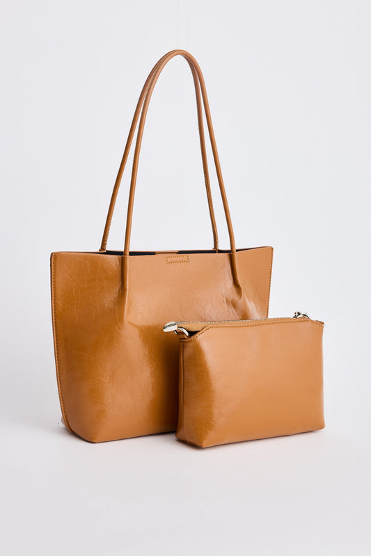 Tan leather tote bag and matching pouch on a white background
