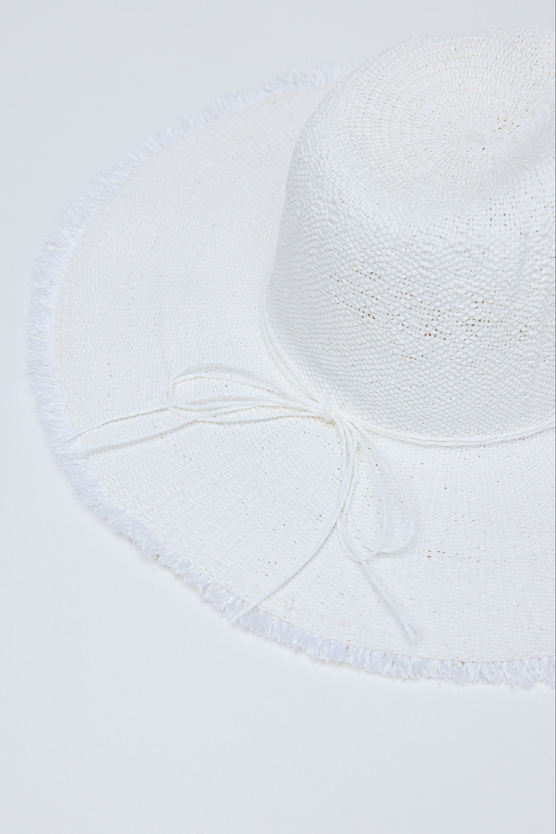 Close-up of a textured white hat on a light gray background