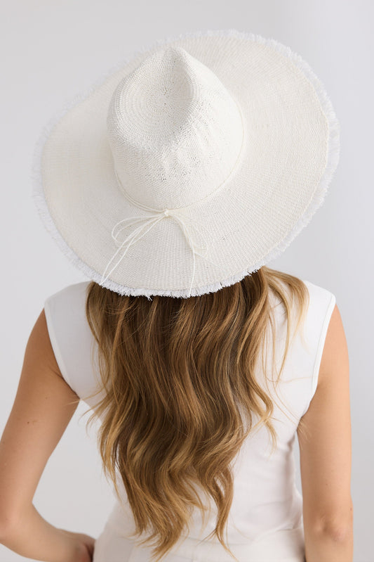 Person wearing a white sun hat on a plain background