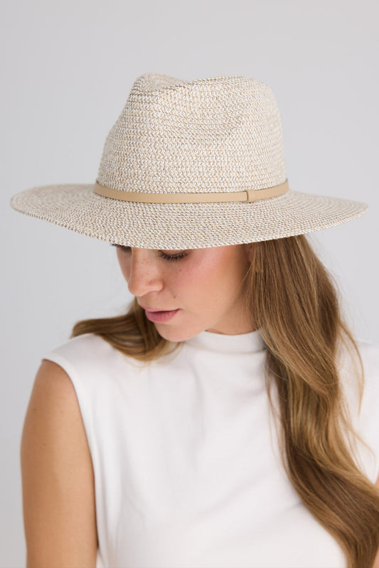 Woman wearing a grey straw hat with a brown band on a light gray background