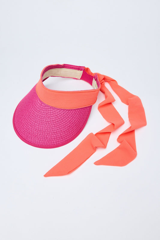 Pink and orange visor with a ribbon on a light gray background