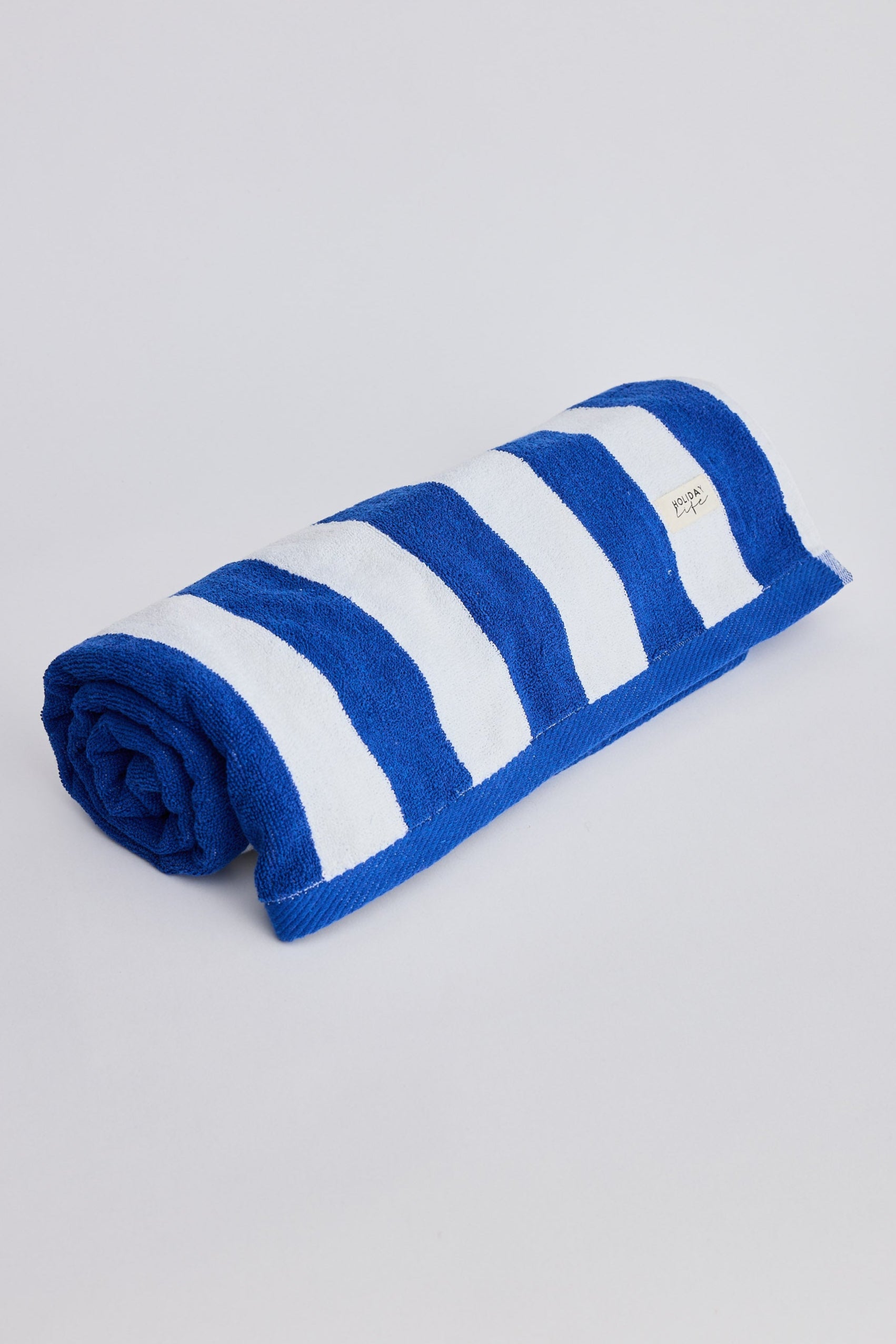 Rolled-up blue and white striped towel on a light gray background