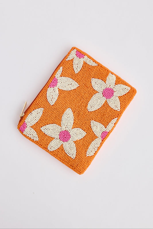 Orange pouch with floral patterns on a light gray background