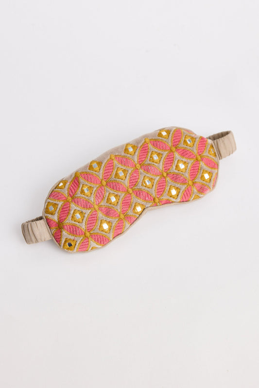 Sleep mask with pink and gold pattern on a white background
