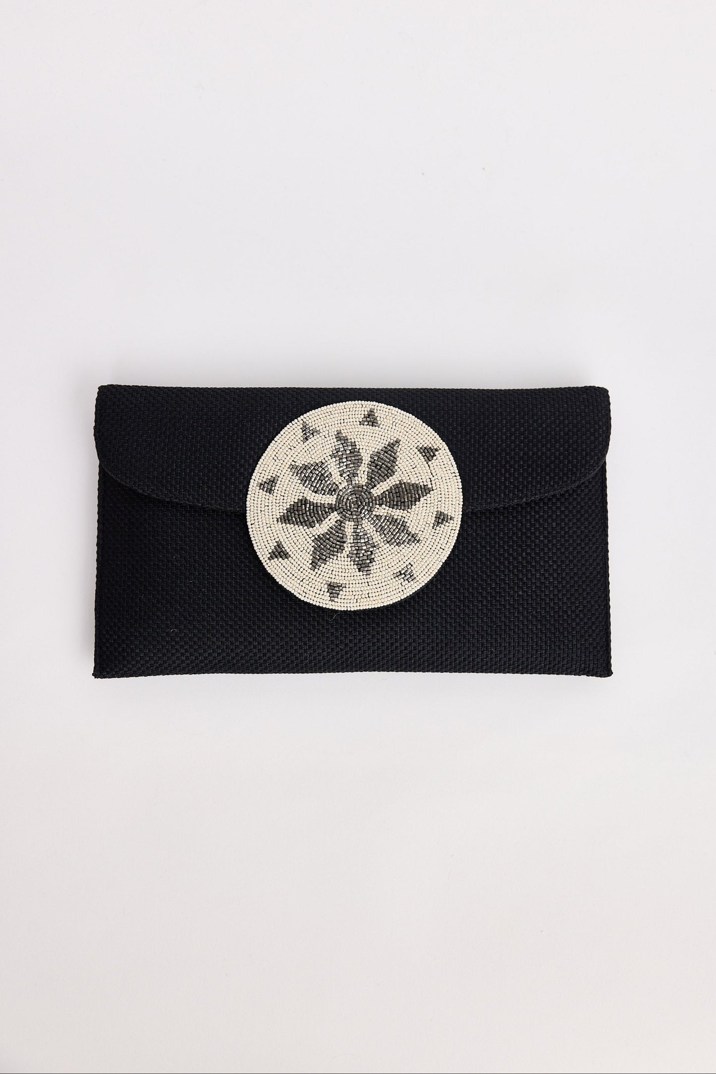 Black clutch with a circular silver design on a white background