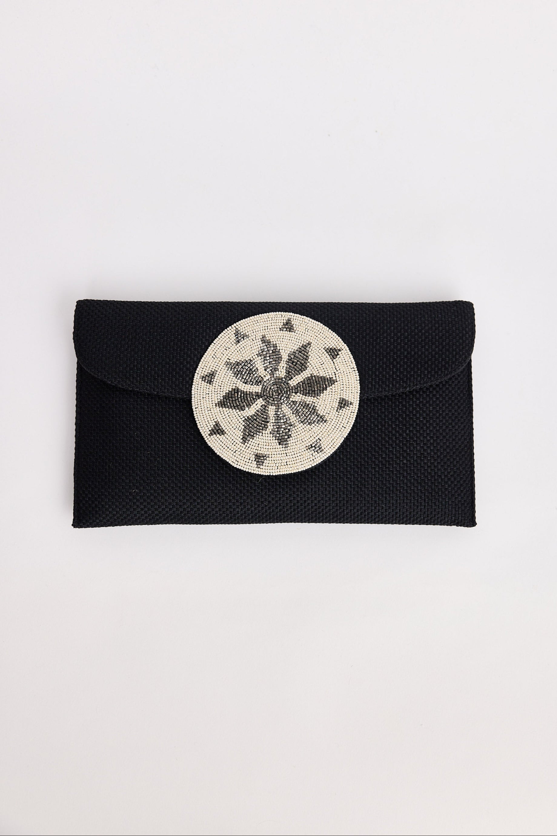 Black clutch with a circular silver design on a white background