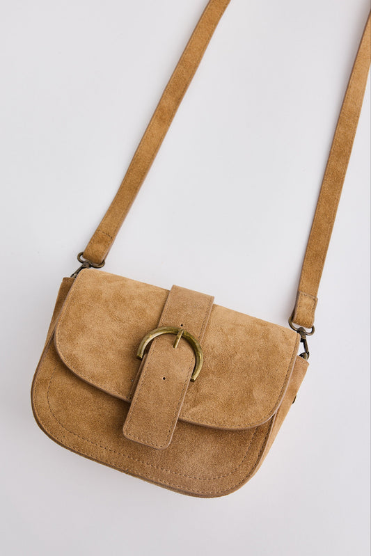 Tan suede handbag with a gold buckle on a white background