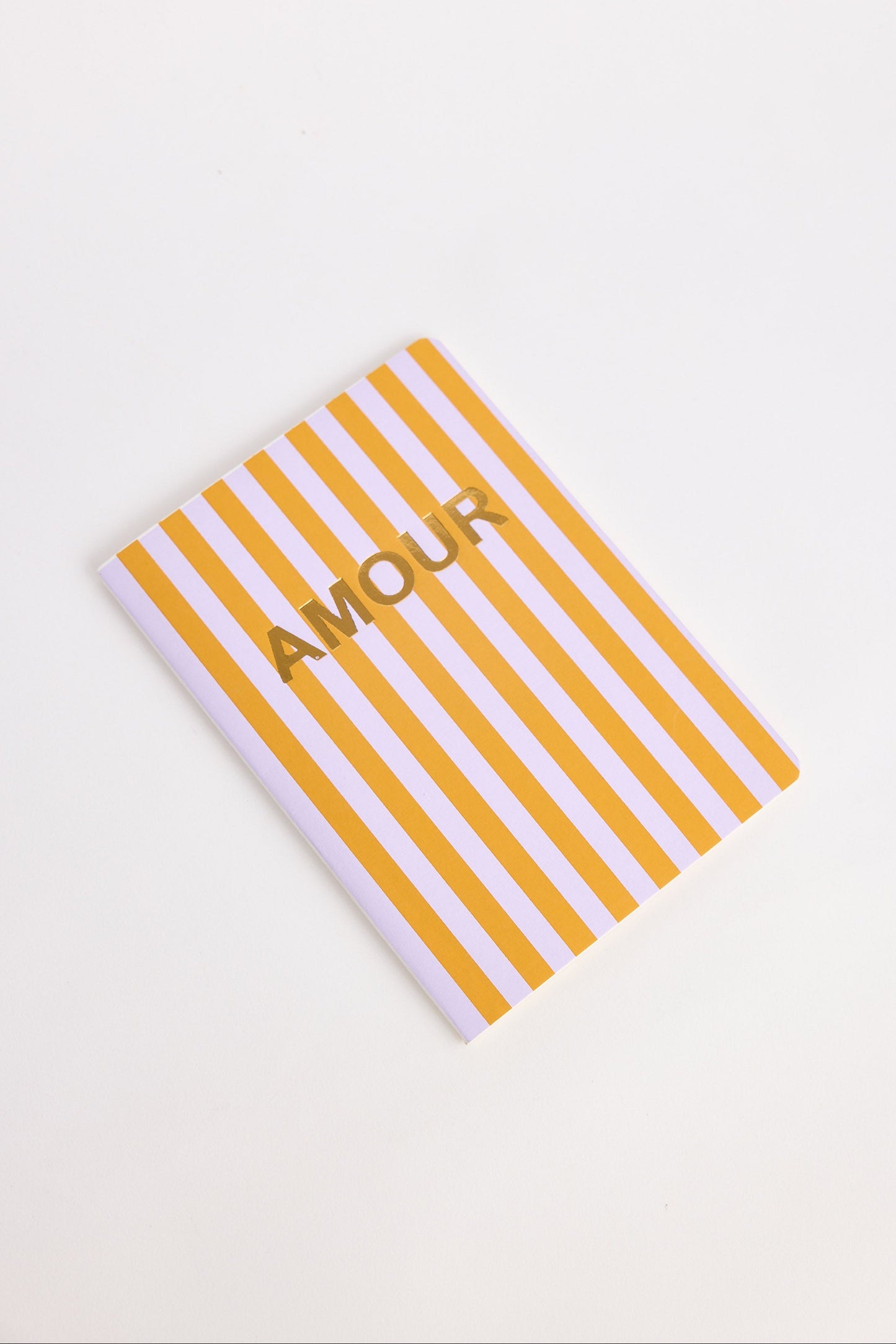 Notebook with orange and lilac striped cover and 'Amour' text on a white background