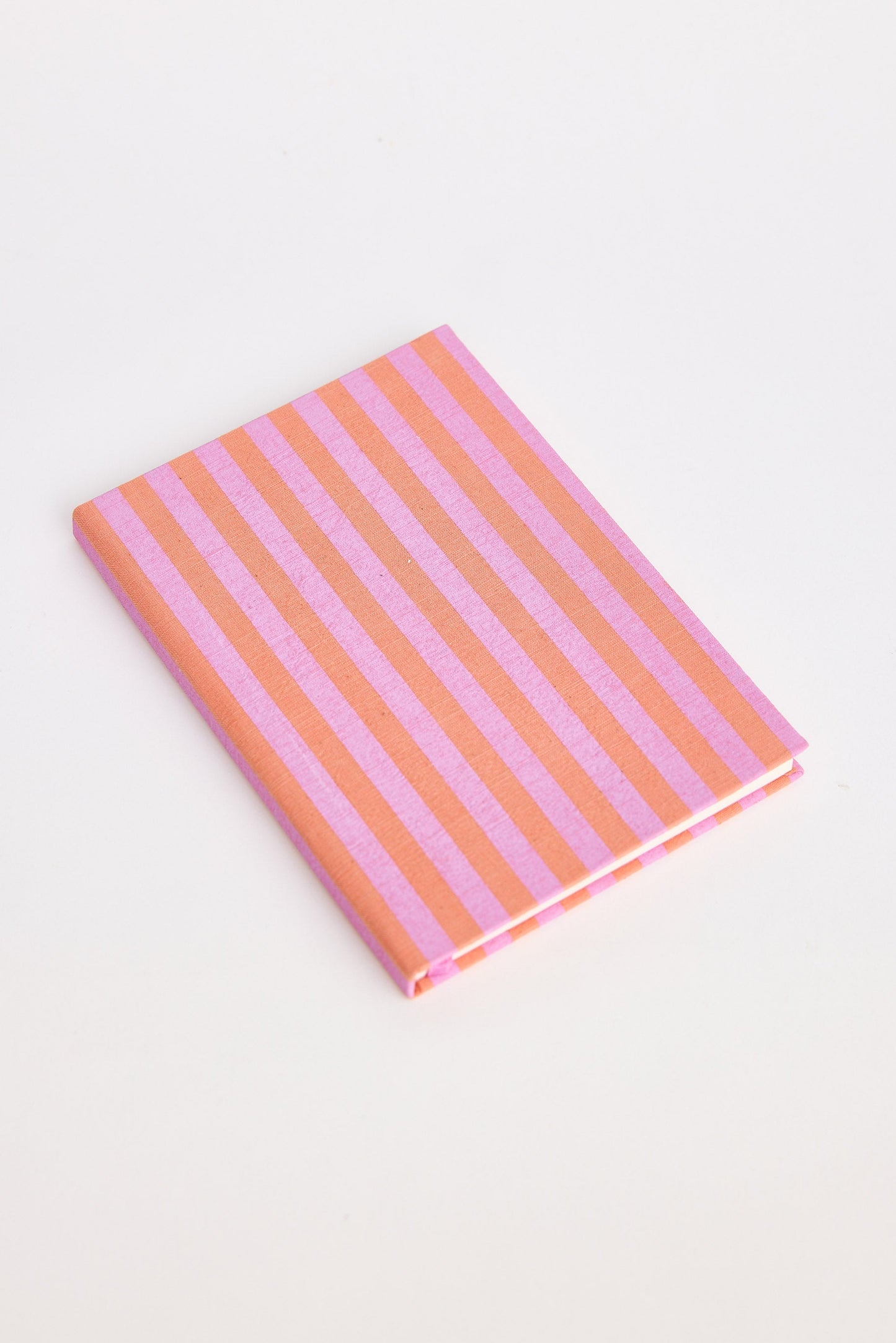 Notebook with pink and orange striped cover on a white background