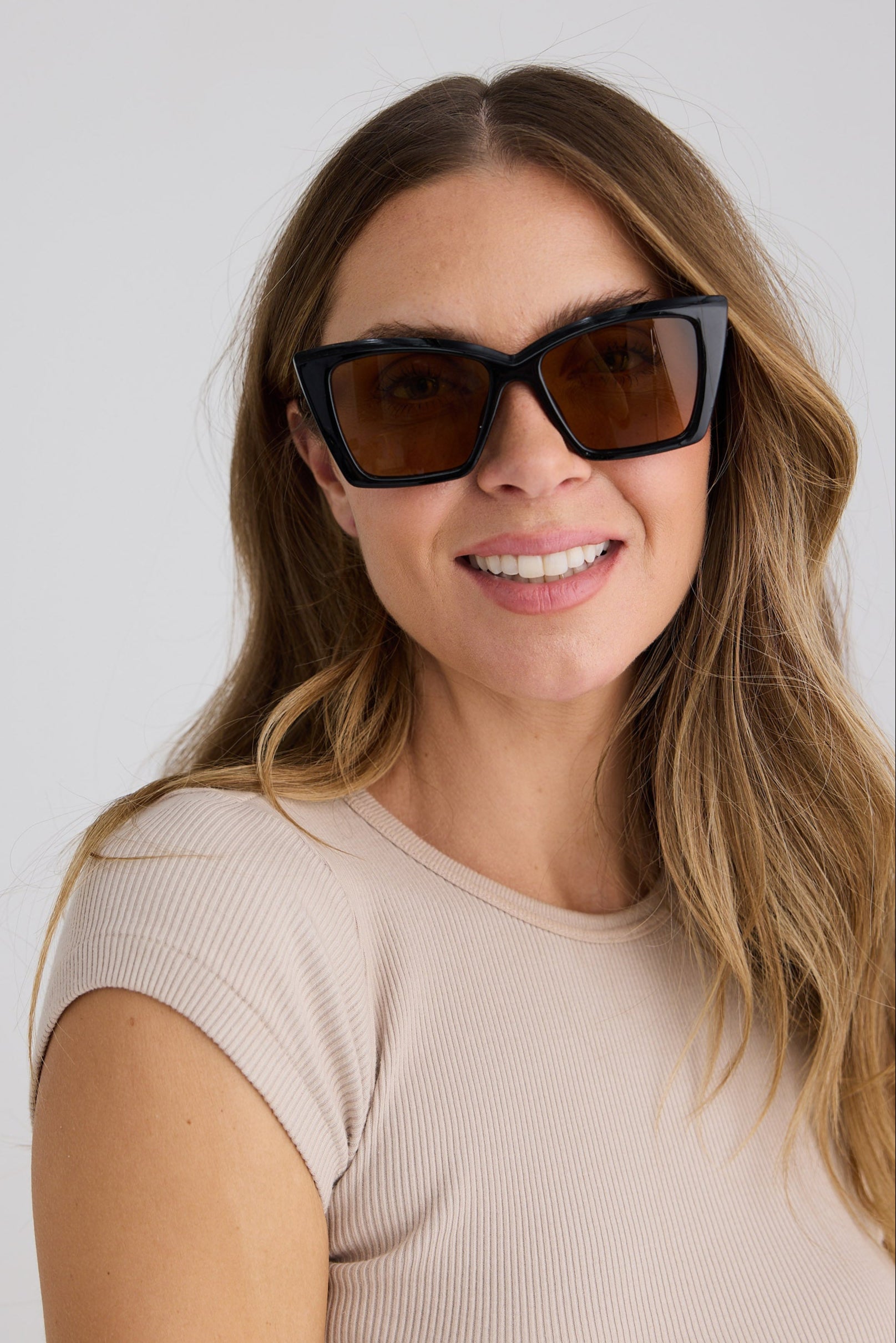 Woman wearing sunglasses with a plain background