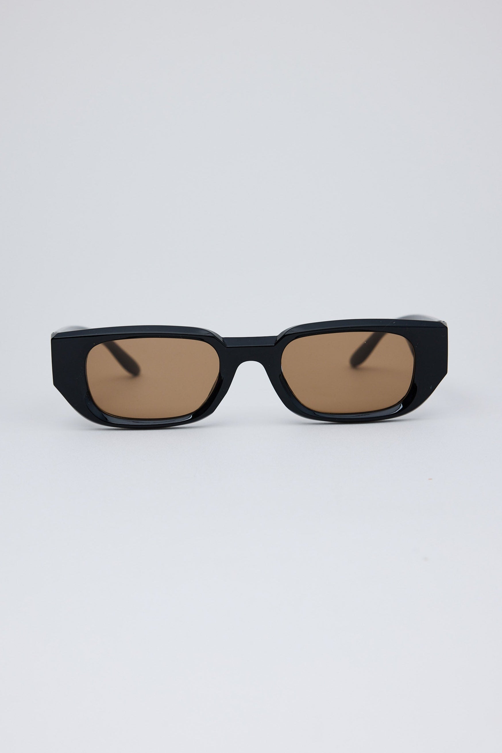Black sunglasses with brown lenses on a white background