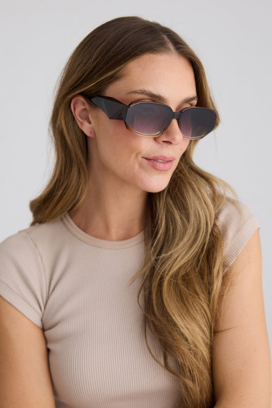 Woman wearing sunglasses with a plain background