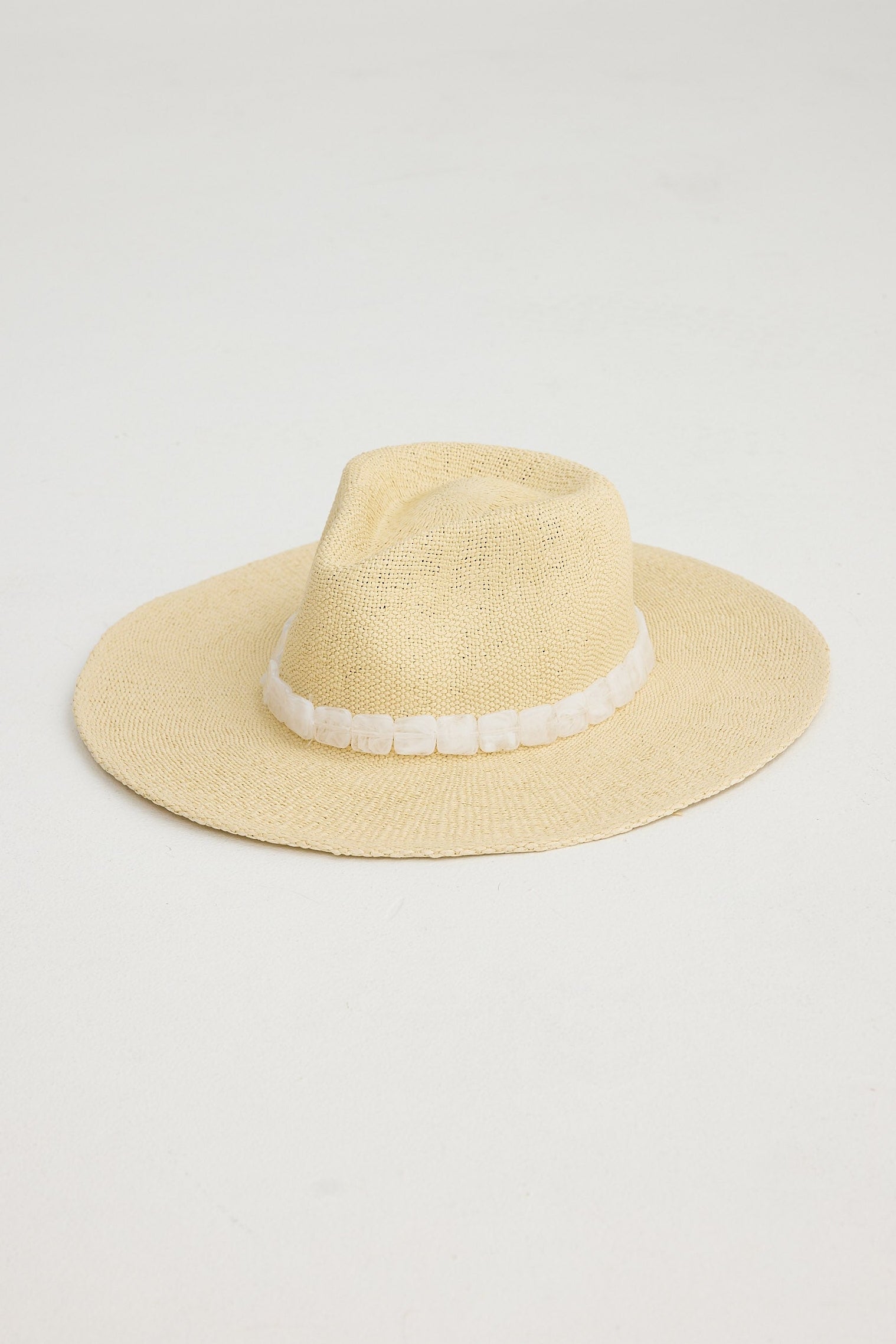 Natural straw hat with a white band on a light gray background