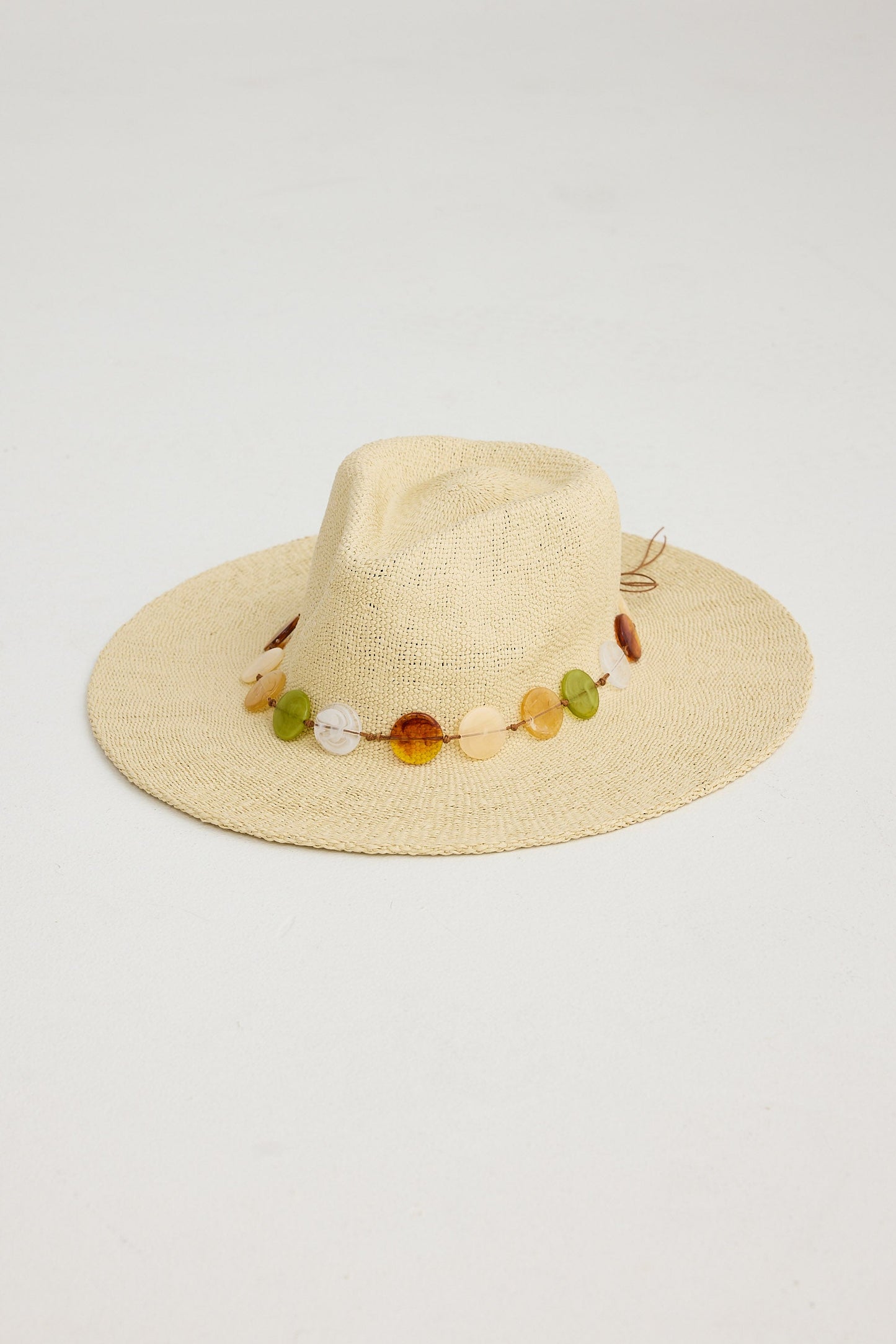Beige straw hat with colorful bead embellishments on a light gray background