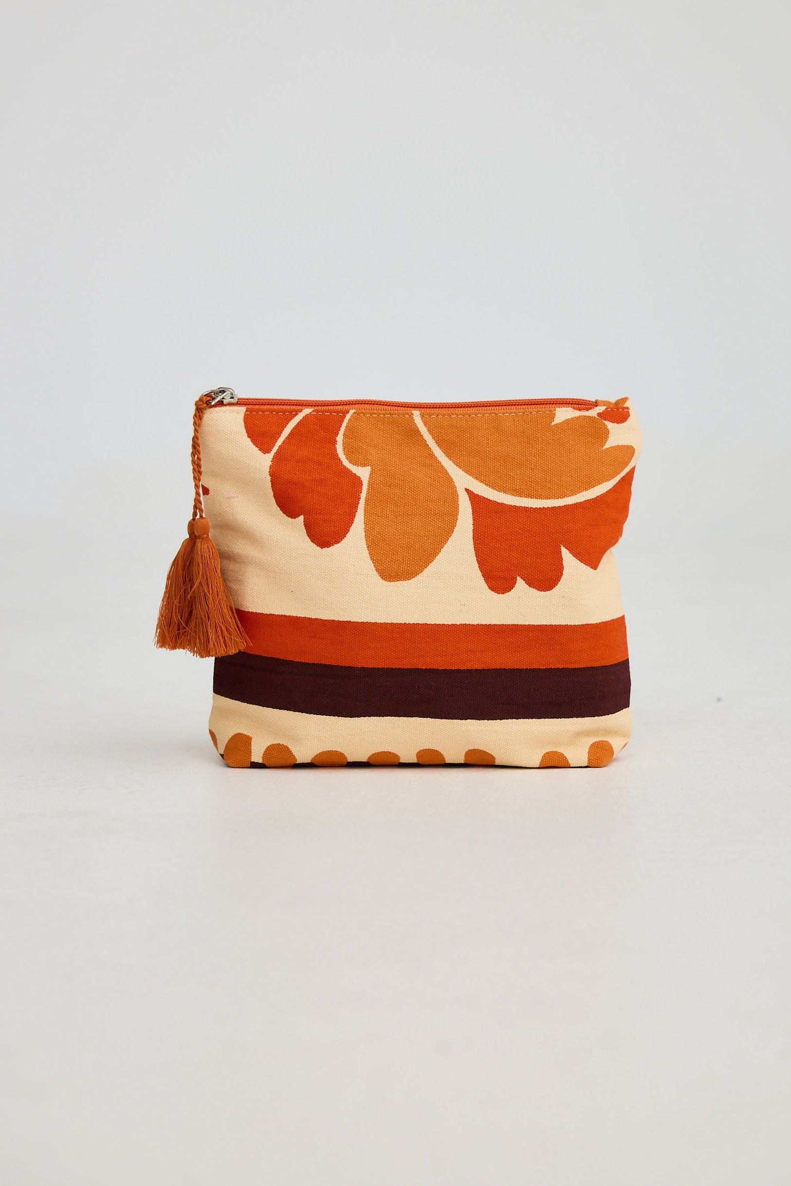 Fabric pouch with floral pattern and tassel on a light gray background