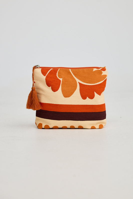 Fabric pouch with floral pattern and tassel on a light gray background