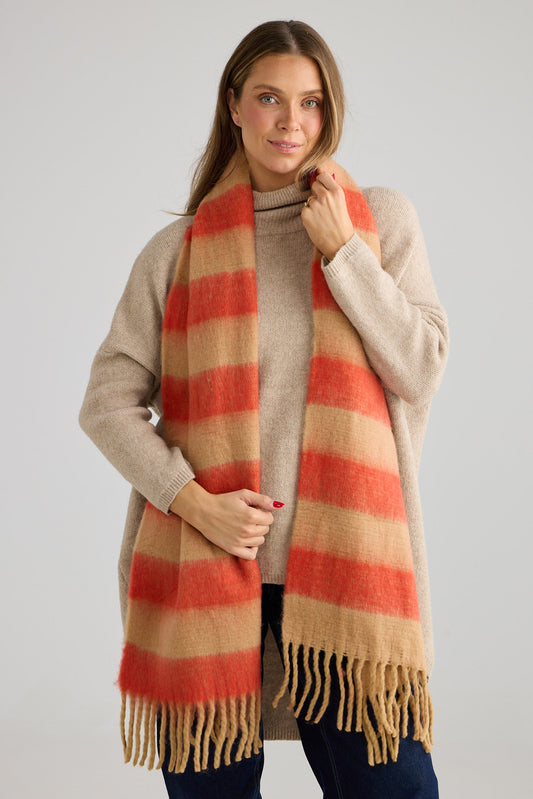 Woman wearing a beige and red striped scarf on a plain background