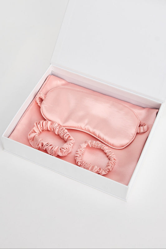Pink satin eye mask in a white box on a light gray background