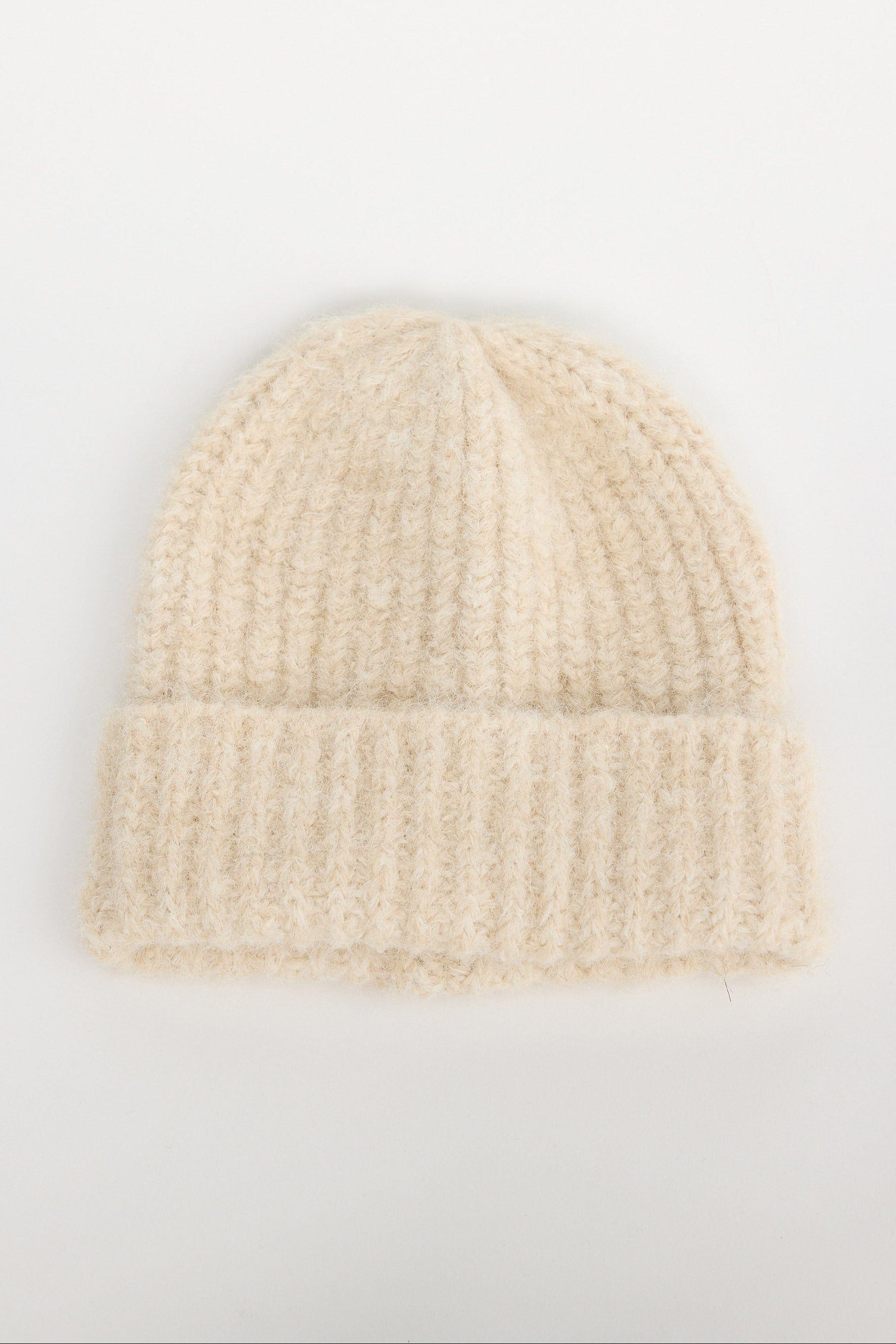 Beige knit beanie on a light gray background
