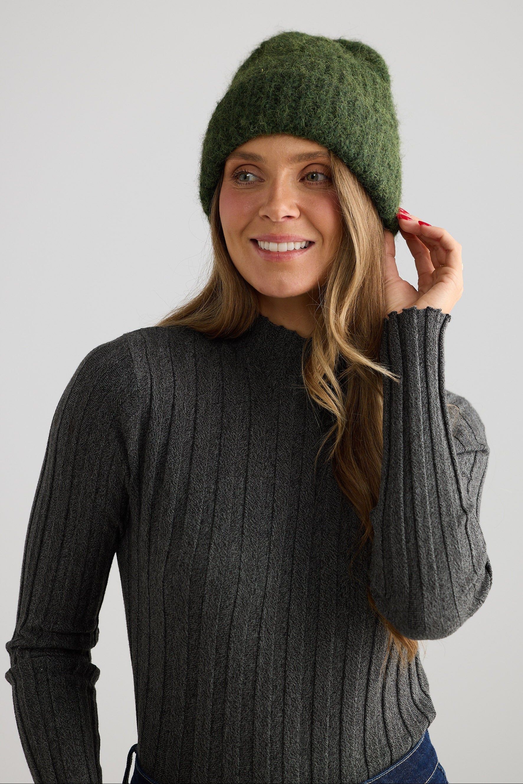 Model wearing Andrea Beanie - Olive beanie in olive with wide rib texture, styled on model view on white background