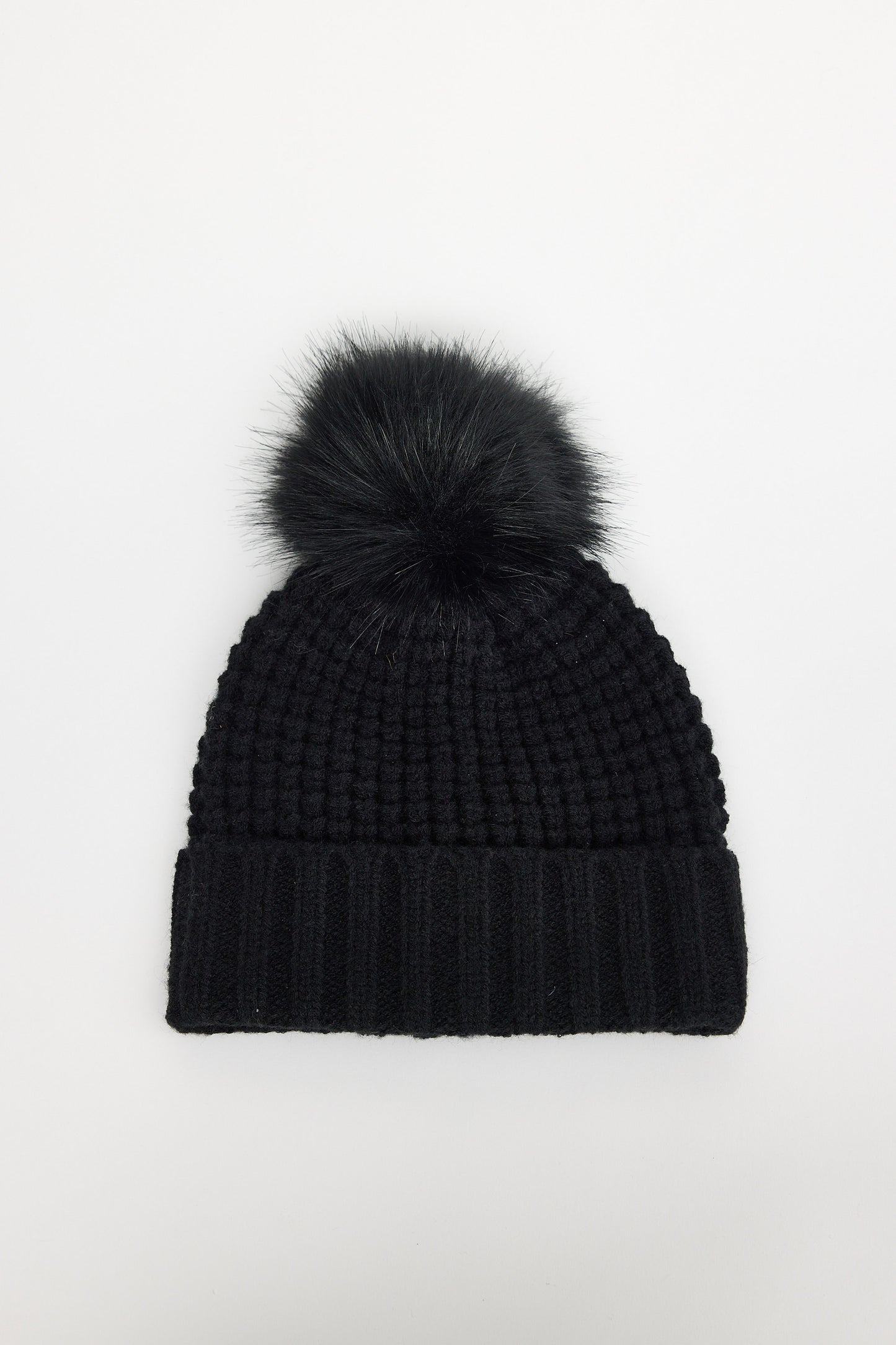 Black knit beanie with a pom-pom on a white background