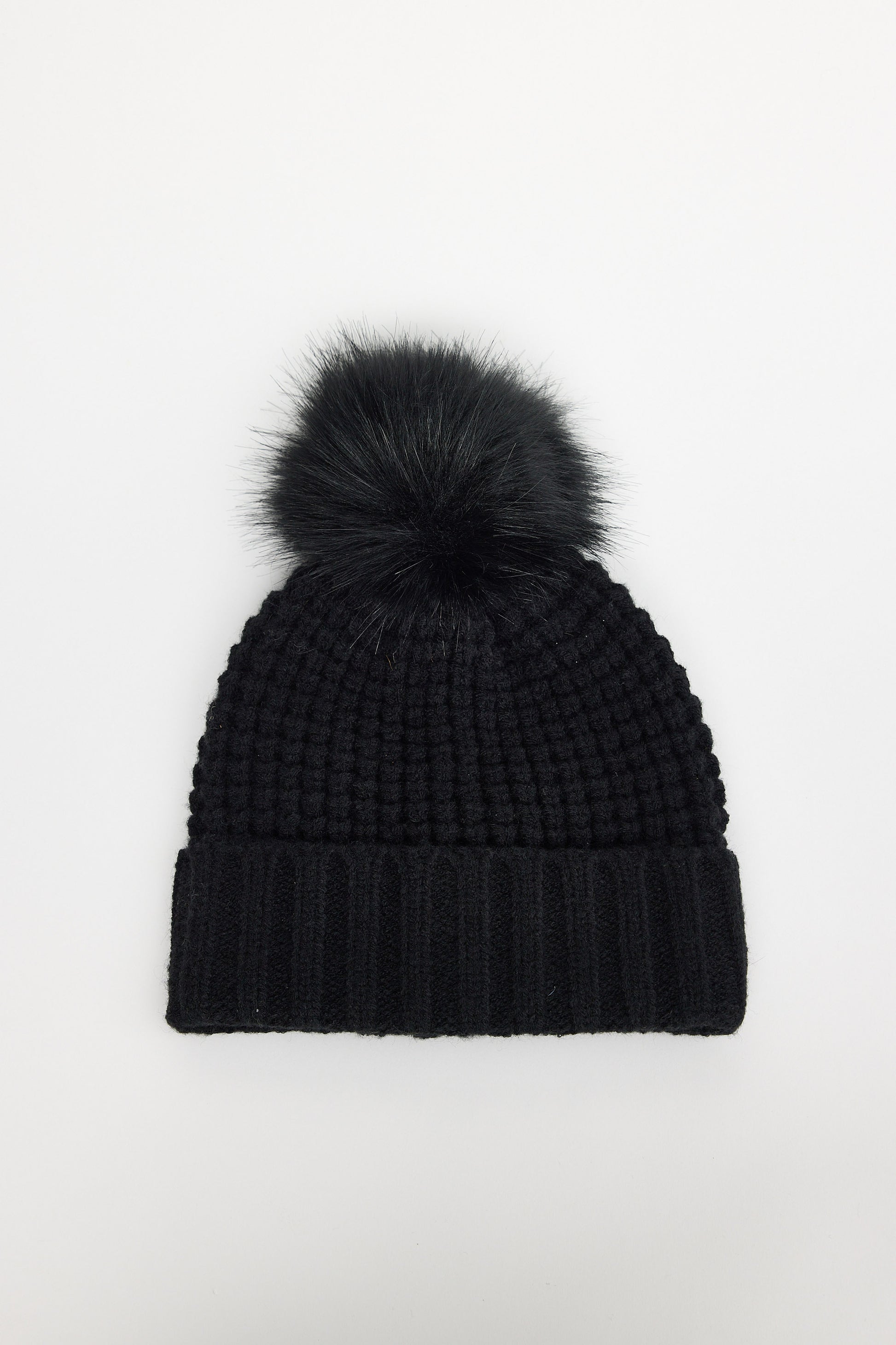 Black knit beanie with a pom-pom on a white background