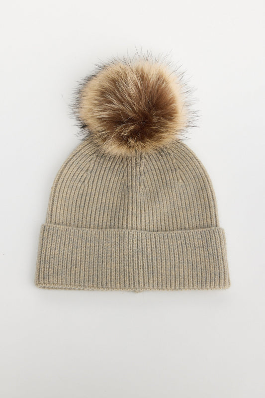 Beige knit beanie with a brown faux fur pom-pom on a white background