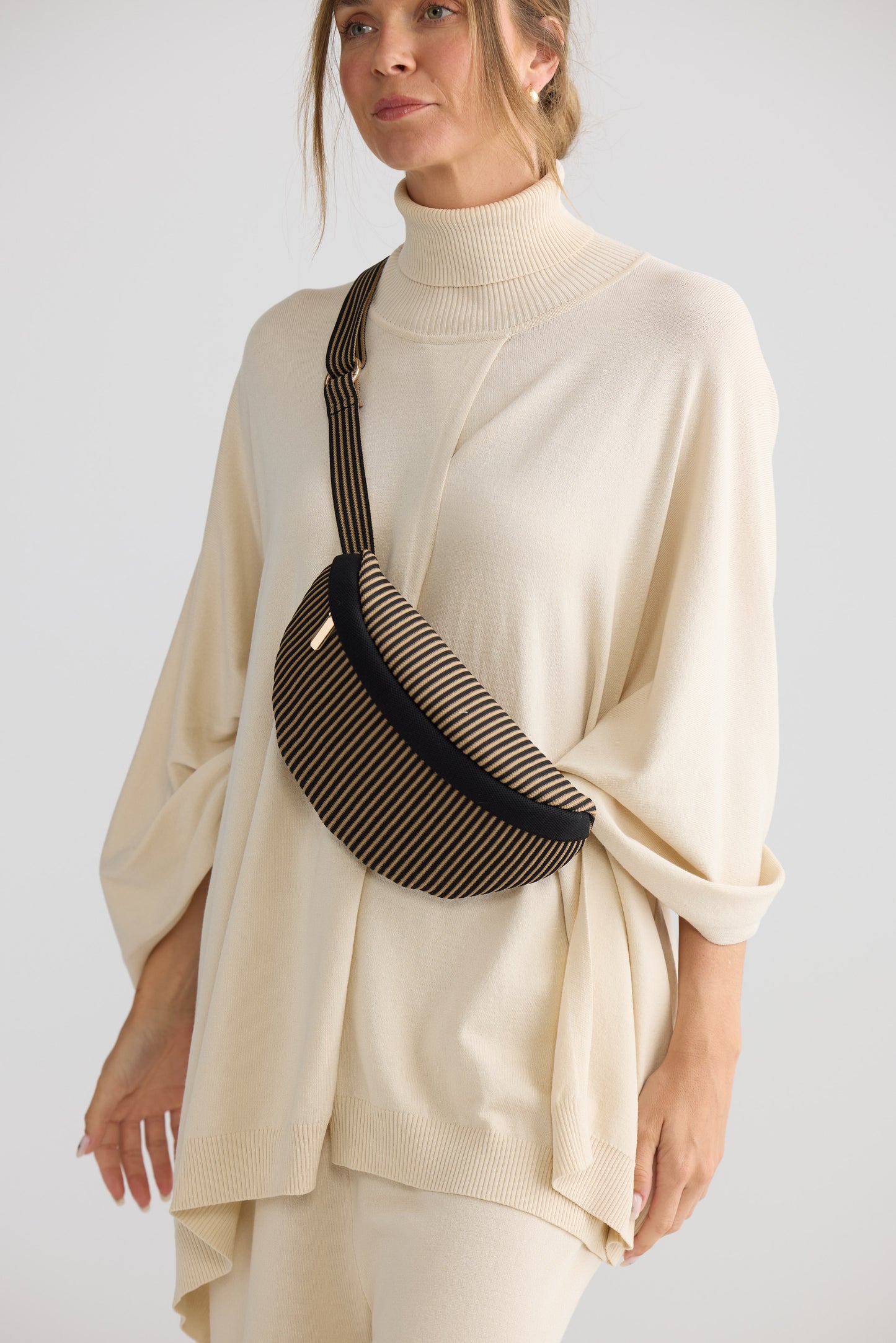 Delphi Bumbag - Black bum bag in black with stripe detailing, styled view on white background